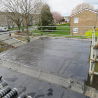 Flat roof renovation with scaffold and first layer of felt