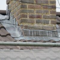 Lead work at the base of a brick chimney stack